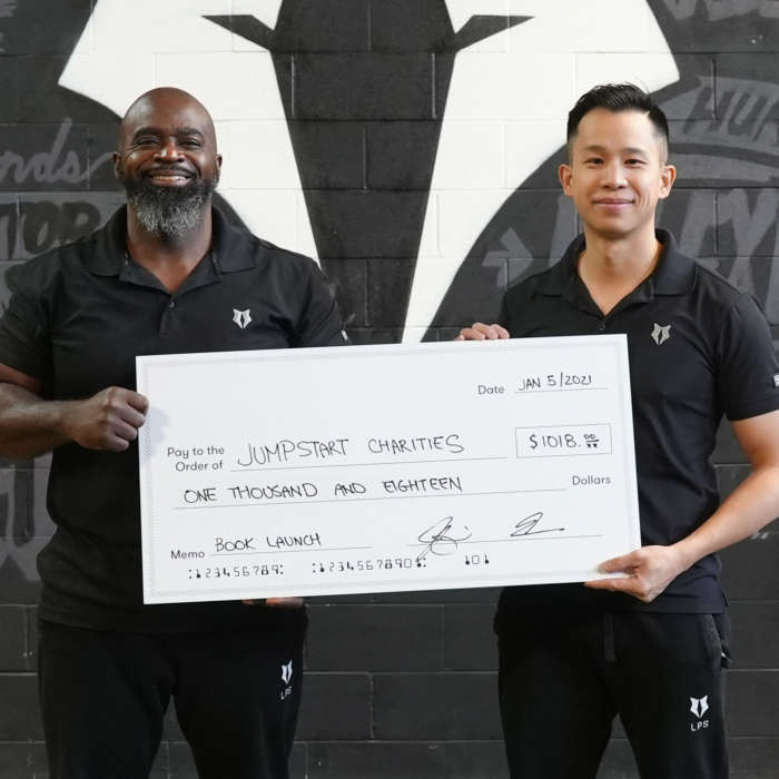 A photo of Clance Laylor and Jeremy Choi holding a donation certificate to the Jumpstart Charities.