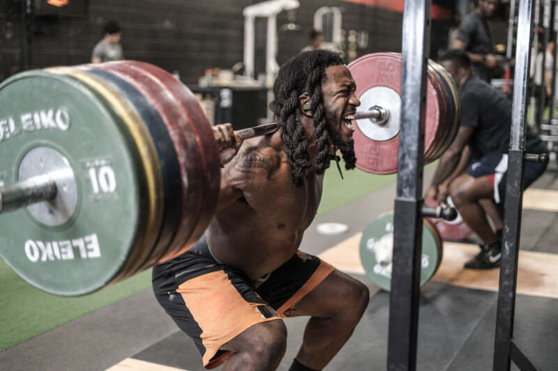 Wayne Moore back squatting.