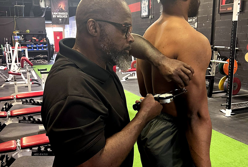 Coach Clance measuring the body fat of one of his CFL and NFL athletes