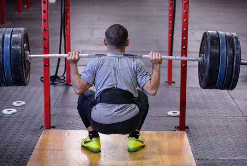 A photo of Mark Bui performing a full range of motion back squat